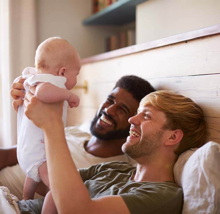 couple holding up baby