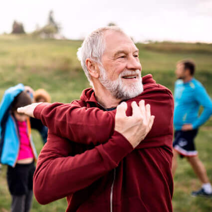 Older man exercising in field