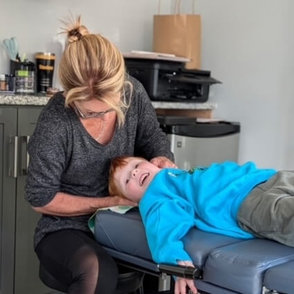 Dr Caplan adjusting kids neck