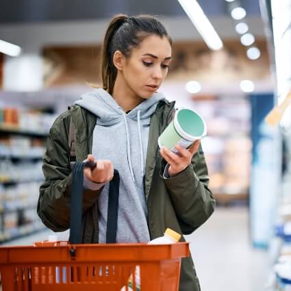 woman reading food label in a grocery store