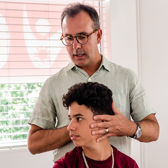 Dr. Roberto adjusting teen's neck