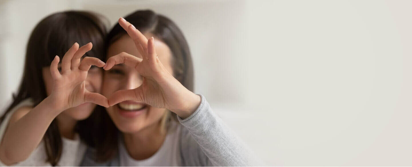 mom and child making heart shape with their hands