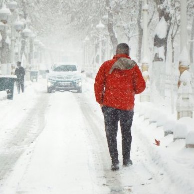 Person walking on a snow-covered street during winter