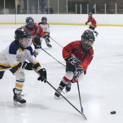 kids playing ice hockey on ice stadium