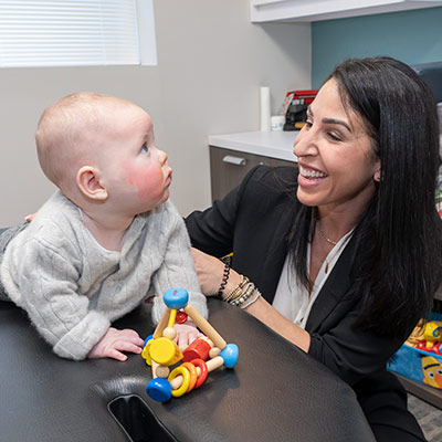 Dr Shara smiling at a baby