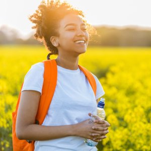 teen with bagpack in field