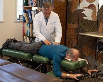 Chiropractic Care Male chiropractor treating his patient