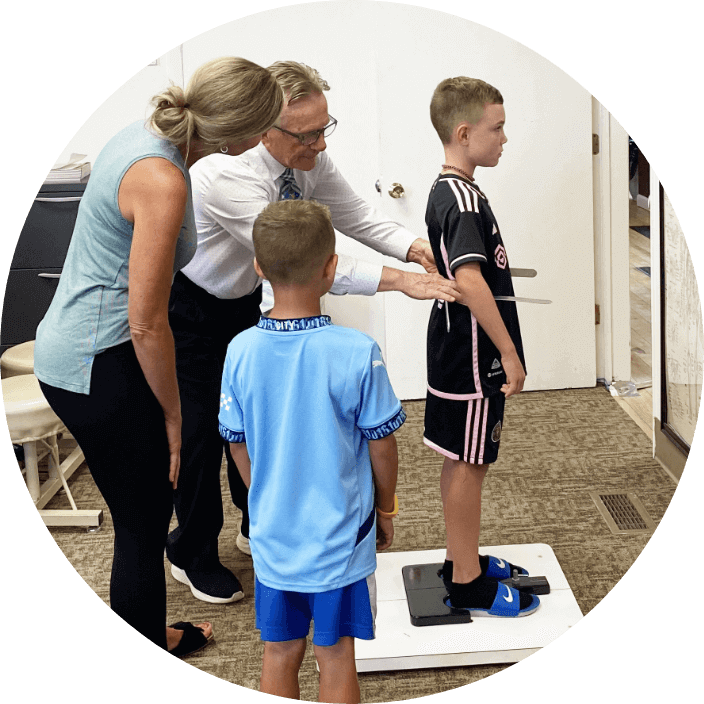 Chiropractor checking kid patients posture