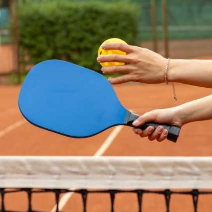 a person holding a tennis racket and a ball