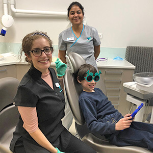 Child in dental chair with glasses on