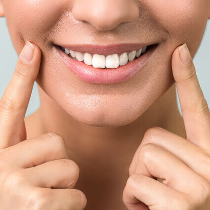 smiling-woman-with-fingers-on-cheeks-sq (1)