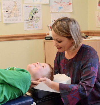 Dr. Alison giving chiropractic adjustment to a child. 