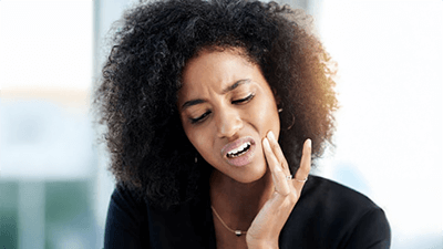 woman touching painful jaw