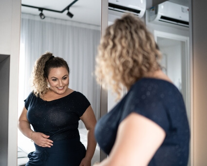 Happy lady looking at a mirror