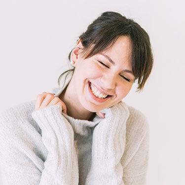 woman in a white sweater, smiling