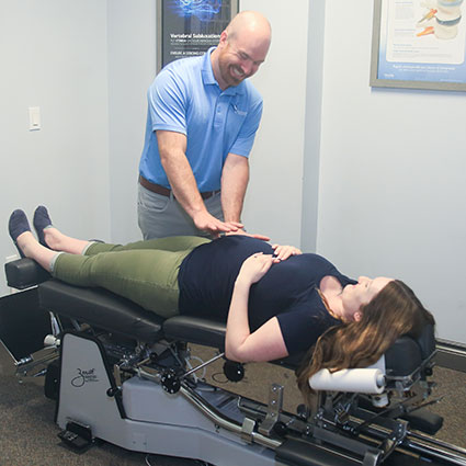 Dr. Aaron adjusting pregnant woman's belly