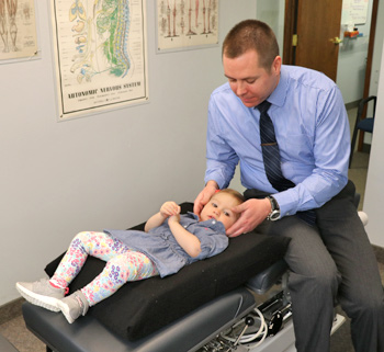 Dr. Ryan adjusts a child 