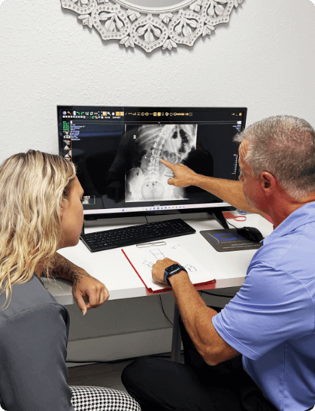 Coastal Chiropractic Chiropractor pointing to spine x-ray