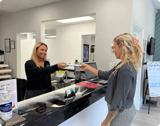 receptionist handling form to patient