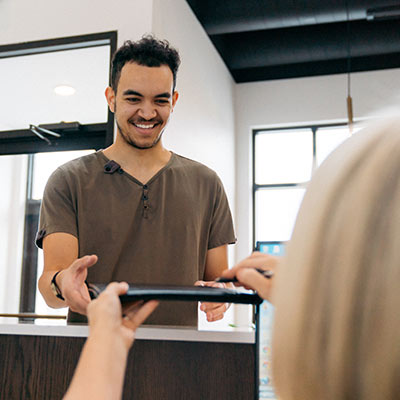 smiling patient checking in at the front desk