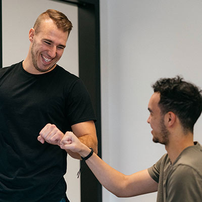 smiling patient fist bumping chiropractor