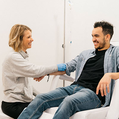 patient and technician smiling during iv fusion therapy