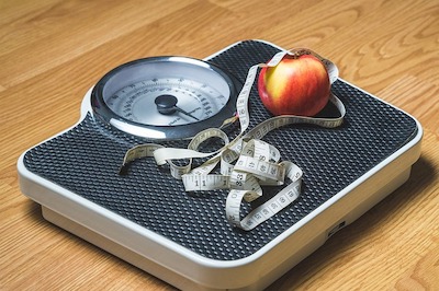 scale with an apple and a tape measure