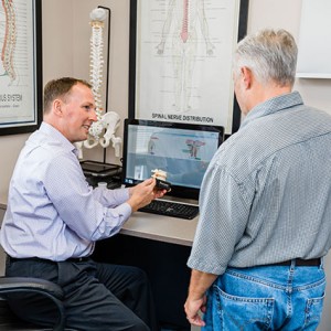 Dr. Brown holding spine model by patient