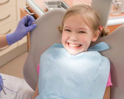 Little smiling girl in dental chair