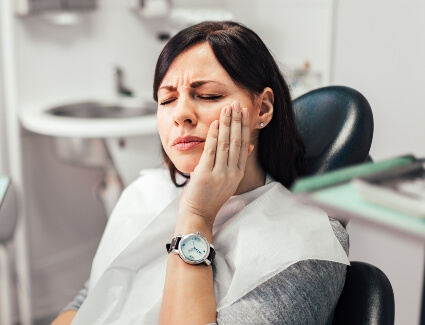 Woman holding jaw in pain