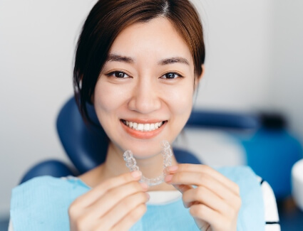 Female patient holding Invisalign