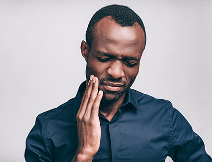 man holding jaw in pain