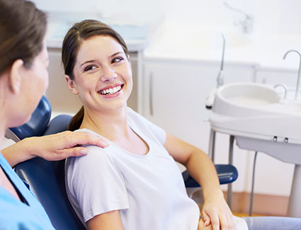person smiling in a dentists chair