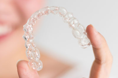 woman holding a clear aligner