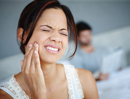 woman holding jaw with dental pain