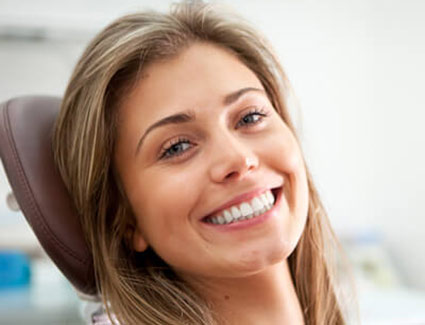 person smiling and sitting in a dental chair