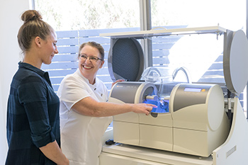 Dr Stender demonstrating Cerec machine to patient