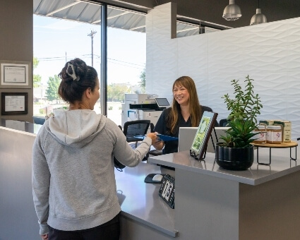 360 Chiropractic & Wellness staff handing over clipboard to patient