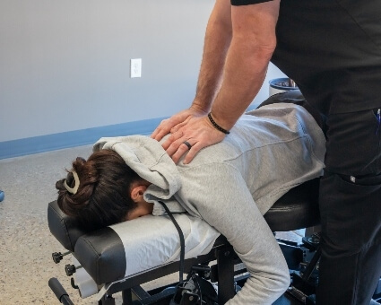 Chiropractor adjusting female patient's back