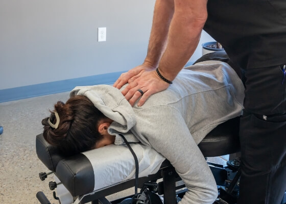 Female patient receiving an upper-back adjustment