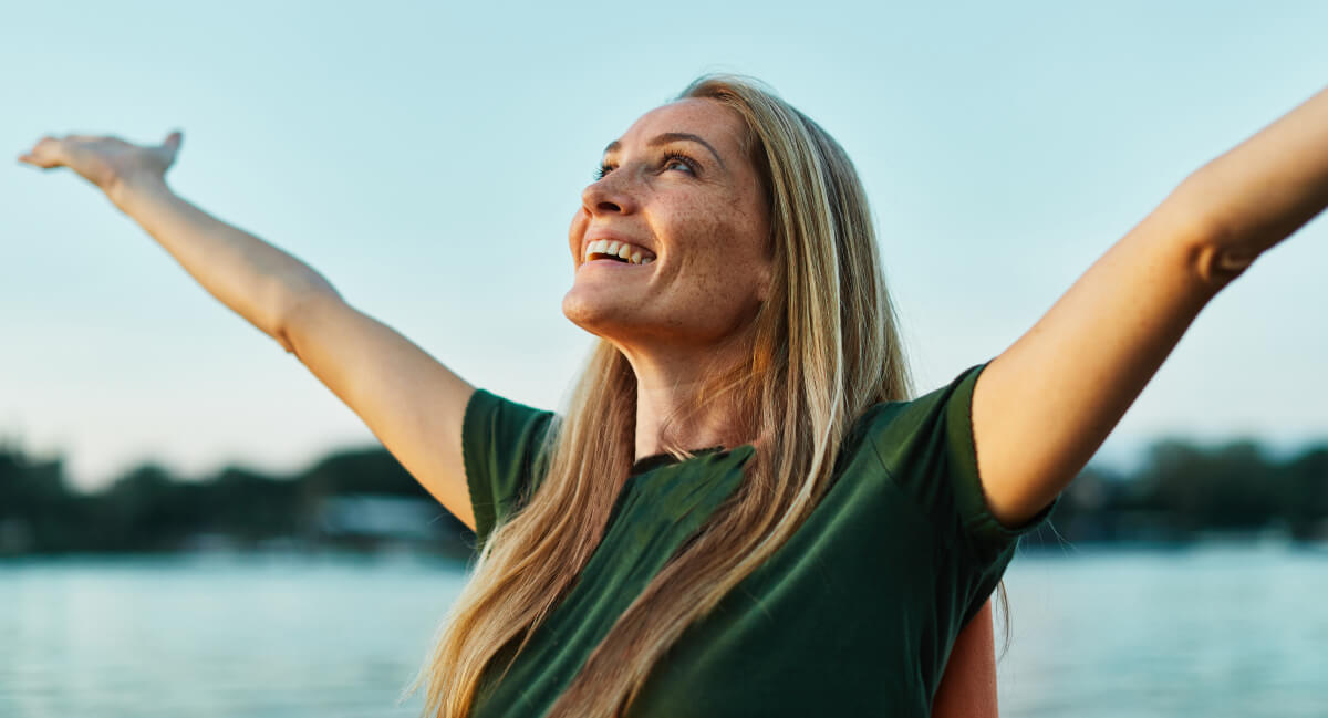 Smiling woman with arms raised
