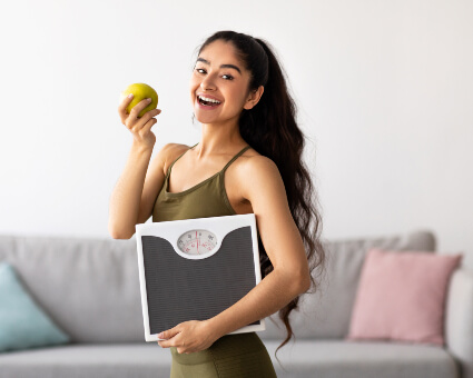 Woman holding an apple and a scale