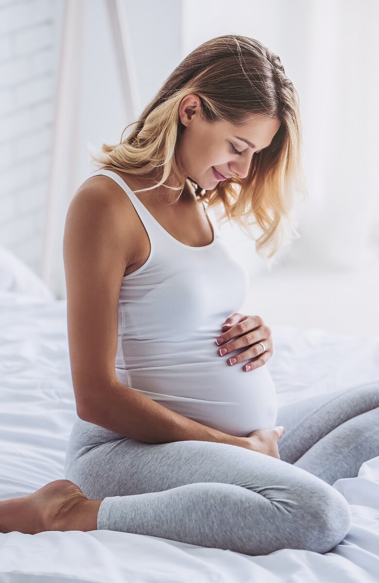 Pregnant lady smiling at tummy