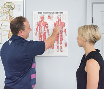 Dr. Brian showing a patient a spinal chart