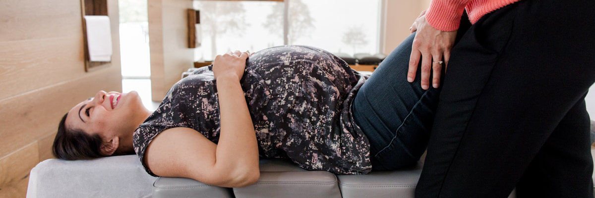 pregnant woman smiling during chiropractic adjustment