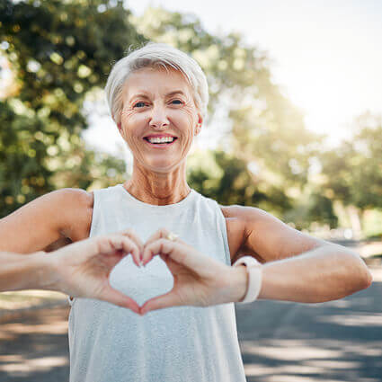 smiling woman making heart shape with hands