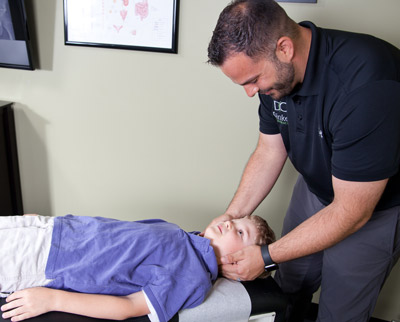 Dr. Dinkel adjusting boys neck.