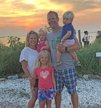 Doctor Thomas Steigerwalt and family with sunset behind them.
