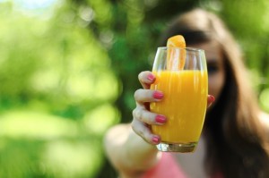 girl holding glass of orange juice