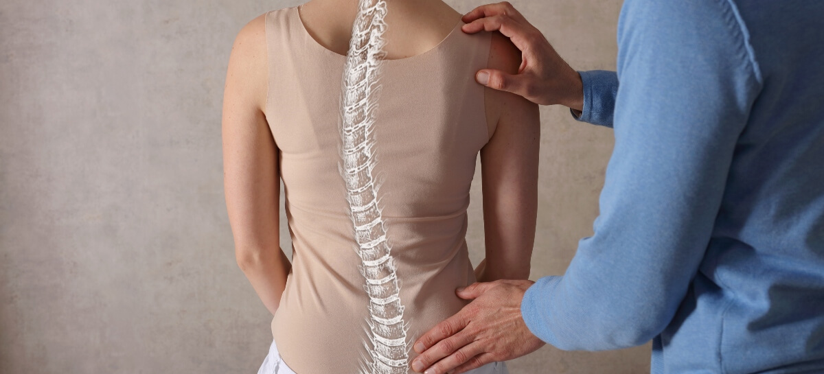 Chiropractor assessing female patient's spine